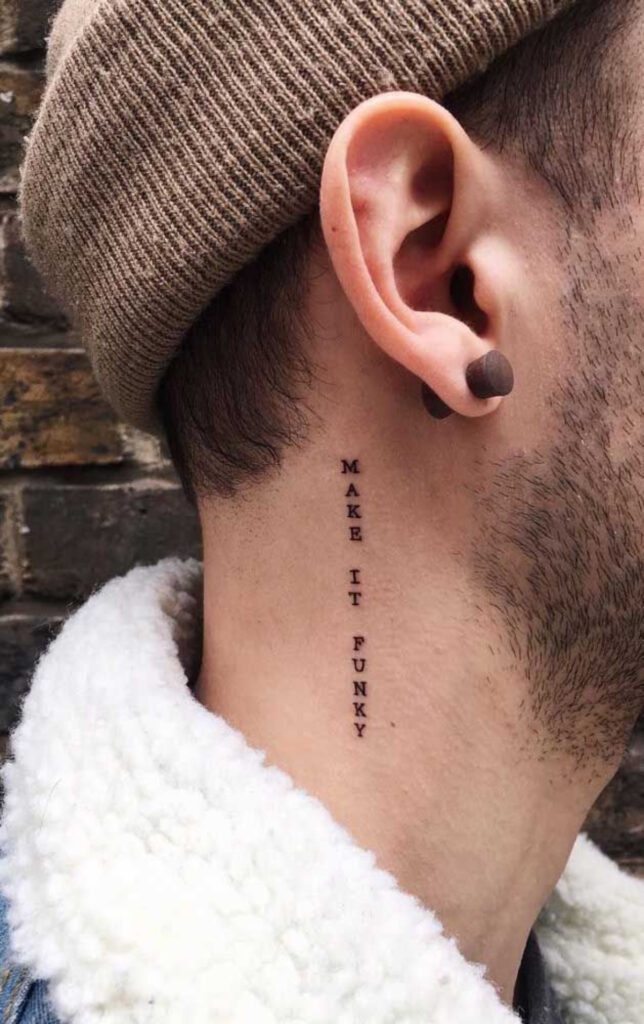 tatuagem delicada com uma frase no pescoço. A frase está na vertical e em inglês. Em protuguês significa: "torne engraçado" 