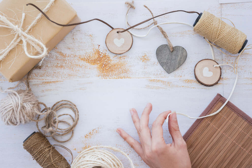 Painel de tricô: linha ou lã, sendo descarrilhada em cima de uma mesa com uma superfície branca com símbolo de coração na cor cinza