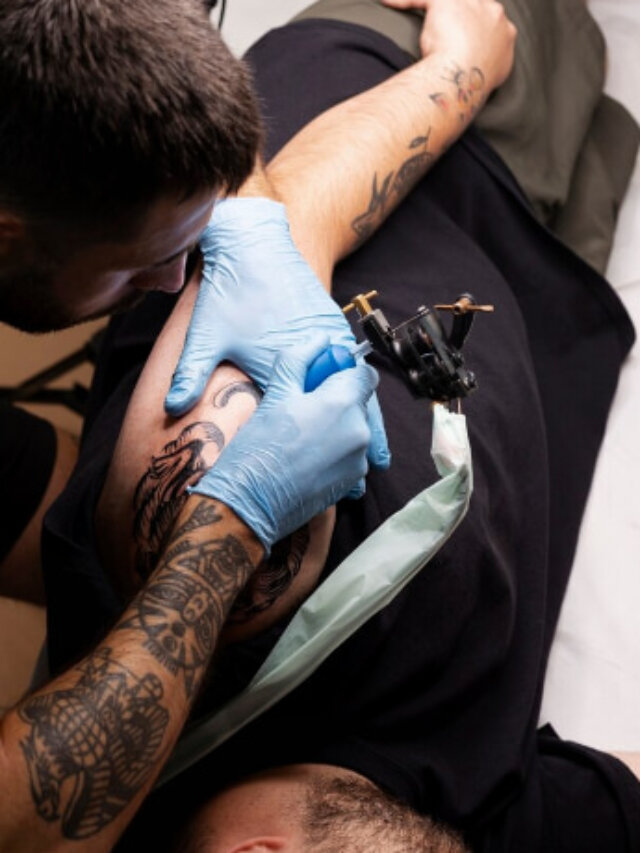 homem tatuando braço