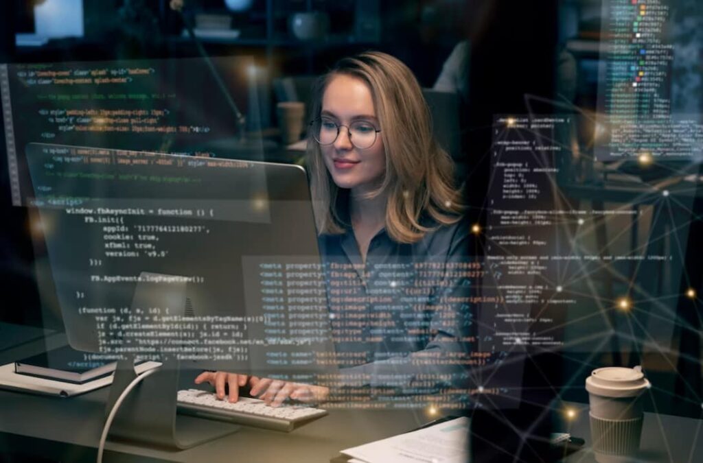 Mulher trabalhando em frente ao computador com diversos dados. Ela espera seu salário de TI